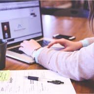 typing laptop Reviewing buy-sell agreement funding paperwork